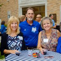 A group of guests standing around a table posing for a photo.